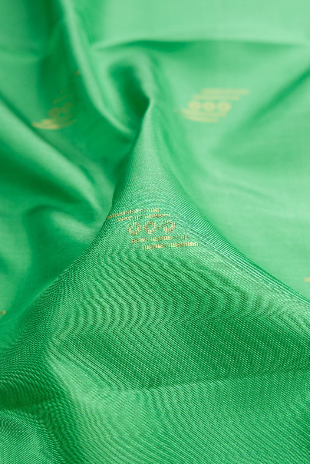 Close up of Pista Green Dual Tone Soft Silk Saree with Zari Butta on the body and Zari Border.  displaying folds