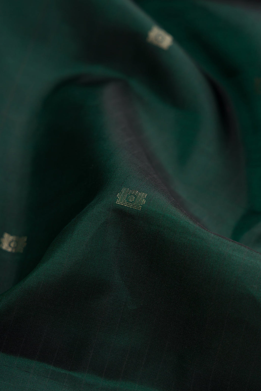 Close up of Bottle Green Dual Tone Soft Silk Saree with Zari Butta on the body and Fancy Border.  displaying folds