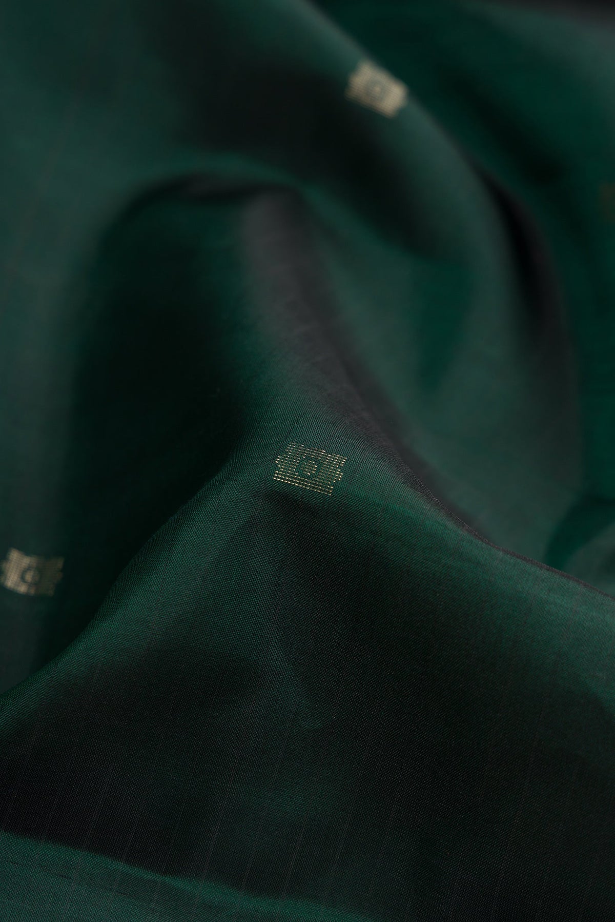 Close up of Bottle Green Dual Tone Soft Silk Saree with Zari Butta on the body and Fancy Border.  displaying folds