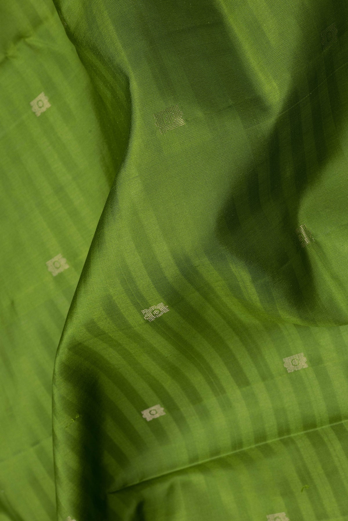 Close up of Green Soft Silk Saree with Zari Butta on the body and Fancy Border.  displaying folds