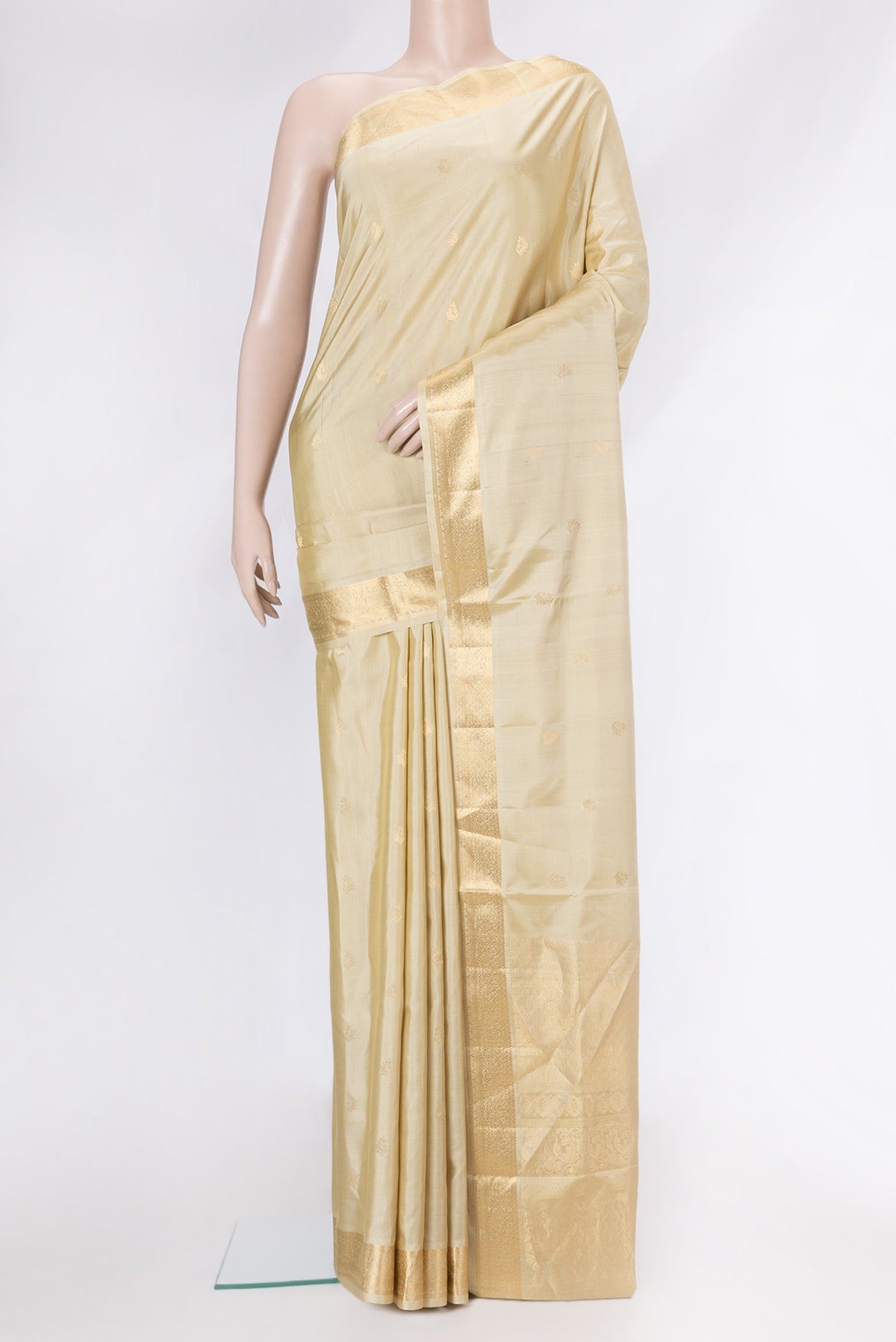 Beige Soft Silk Saree with Zari Butta on the body and Zari Border.  displayed on a mannequin