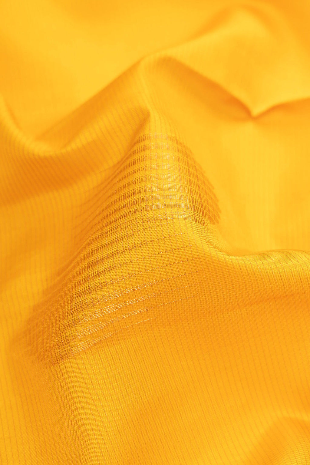 Close up of Yellow Soft Silk Saree with Stripes on the body and Zari Border.  displaying folds