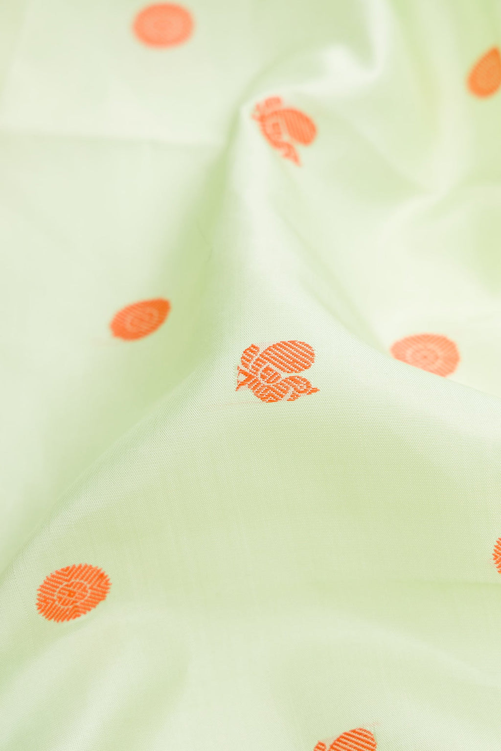 Close up of Pure Silk Pure Zari Pista Green Dual Tone Kanjivaram Saree with Thread Butta on the body and Zari Border.  displaying folds