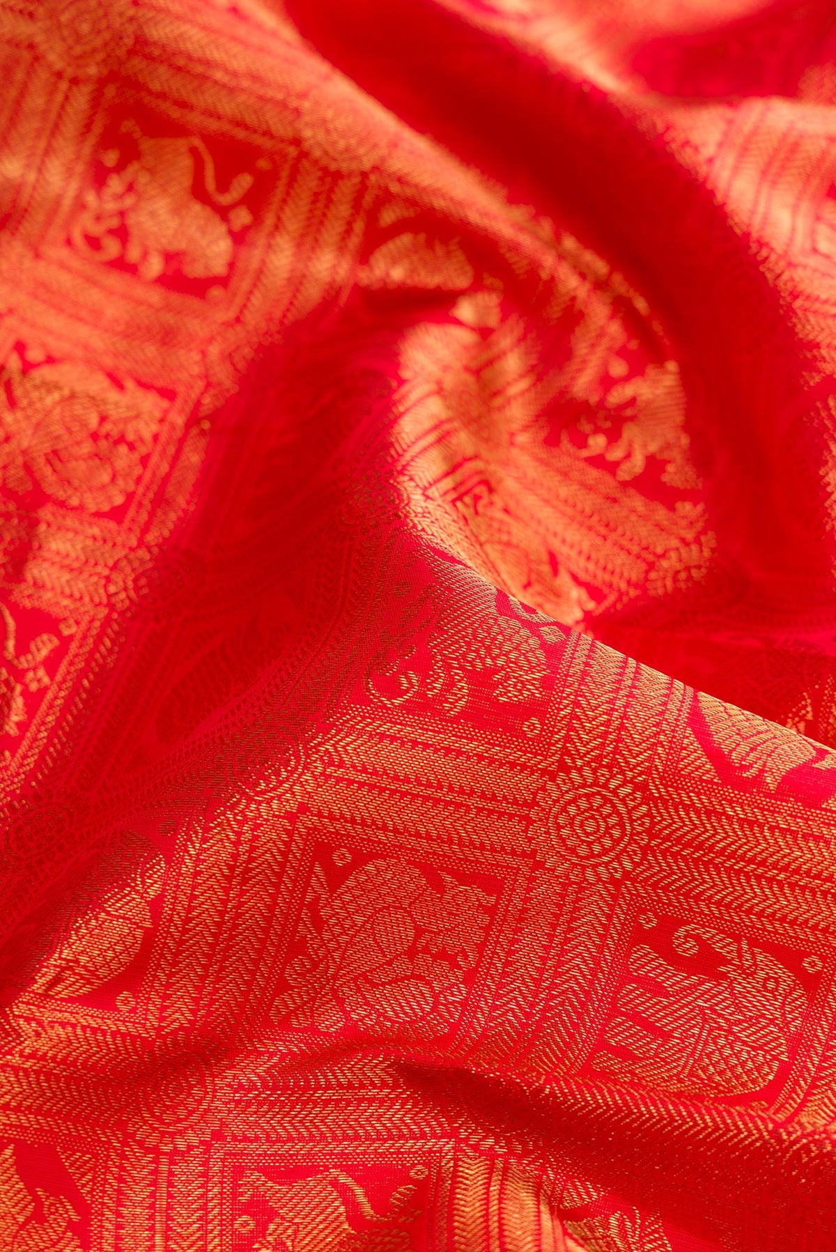 Close up of Pure Silk Pure Zari Red Dual Tone Kanjivaram Saree with Zari Brocade on the body and Zari Border.  displaying folds