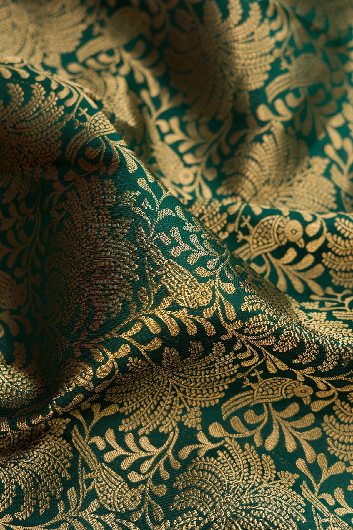 Close up of Bottle Green Kanjivaram Silk Saree with Zari Brocade on the body and Zari Border.  displaying folds