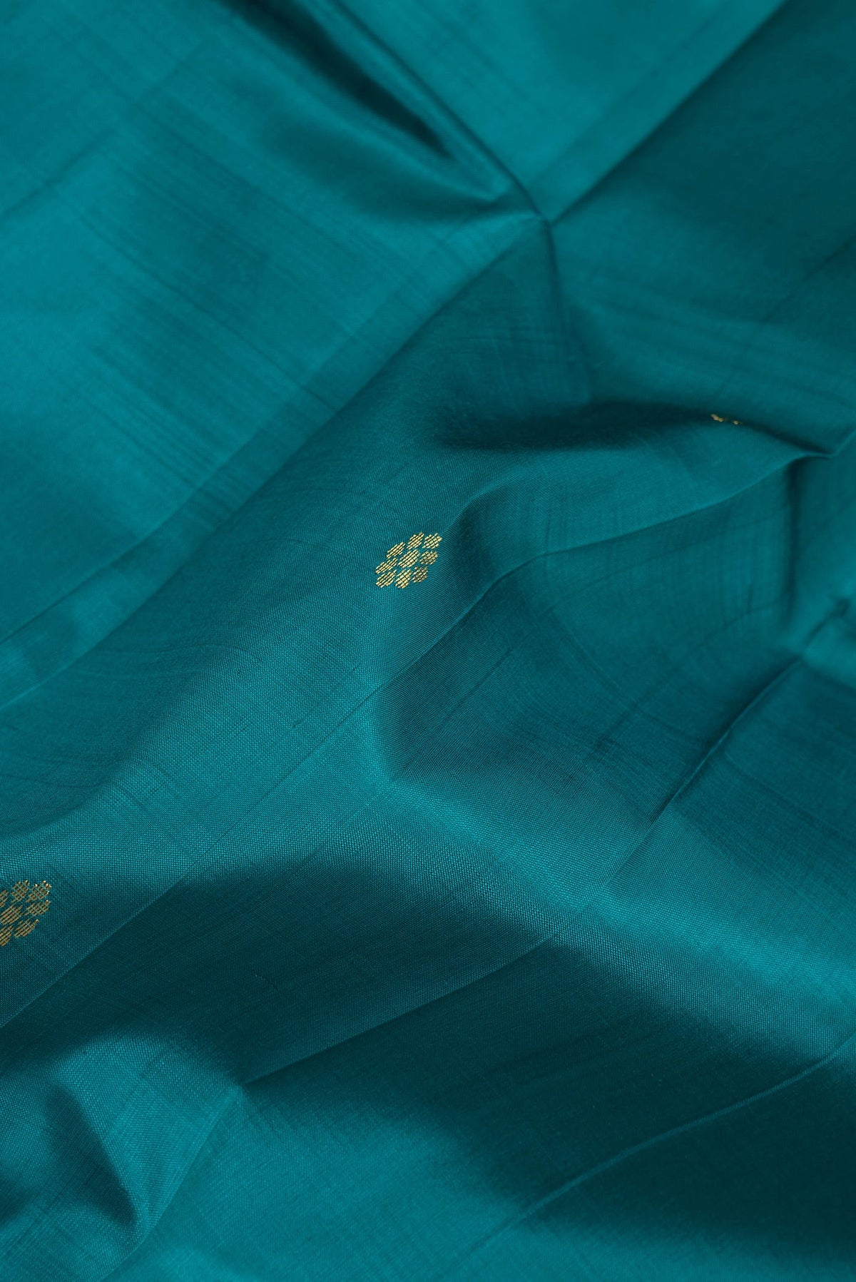 Close up of Peacock Blue Dual Tone Kanjivaram Silk Saree with Zari Butta on the body and One Side Border.  displaying folds