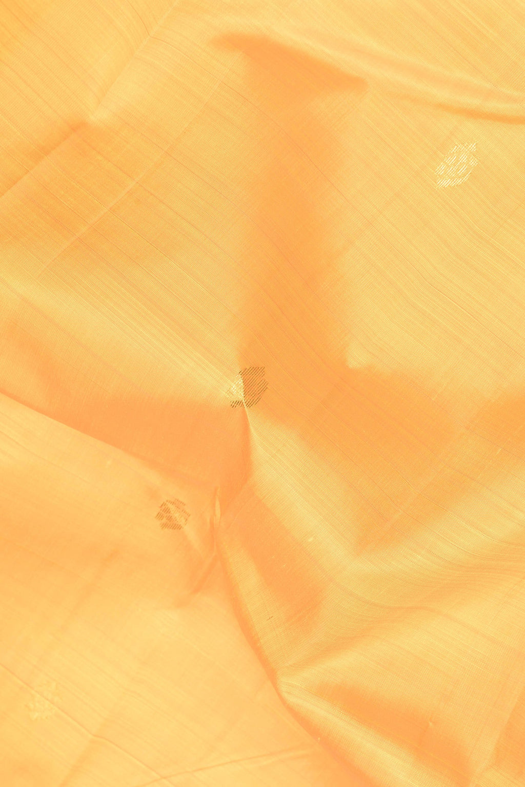 Close up of Yellow Dual Tone Kanjivaram Silk Saree with Zari Butta on the body and Zari Border.  displaying folds