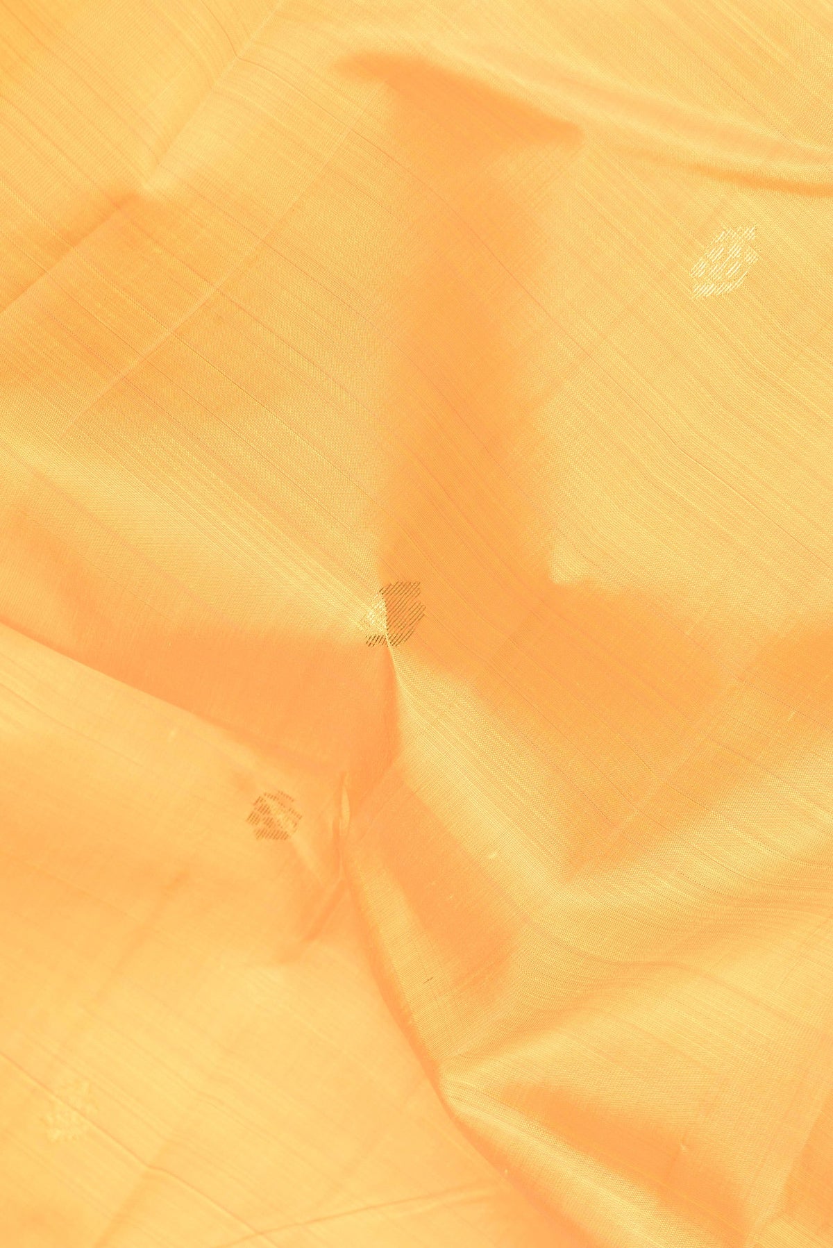 Close up of Yellow Dual Tone Kanjivaram Silk Saree with Zari Butta on the body and Zari Border.  displaying folds