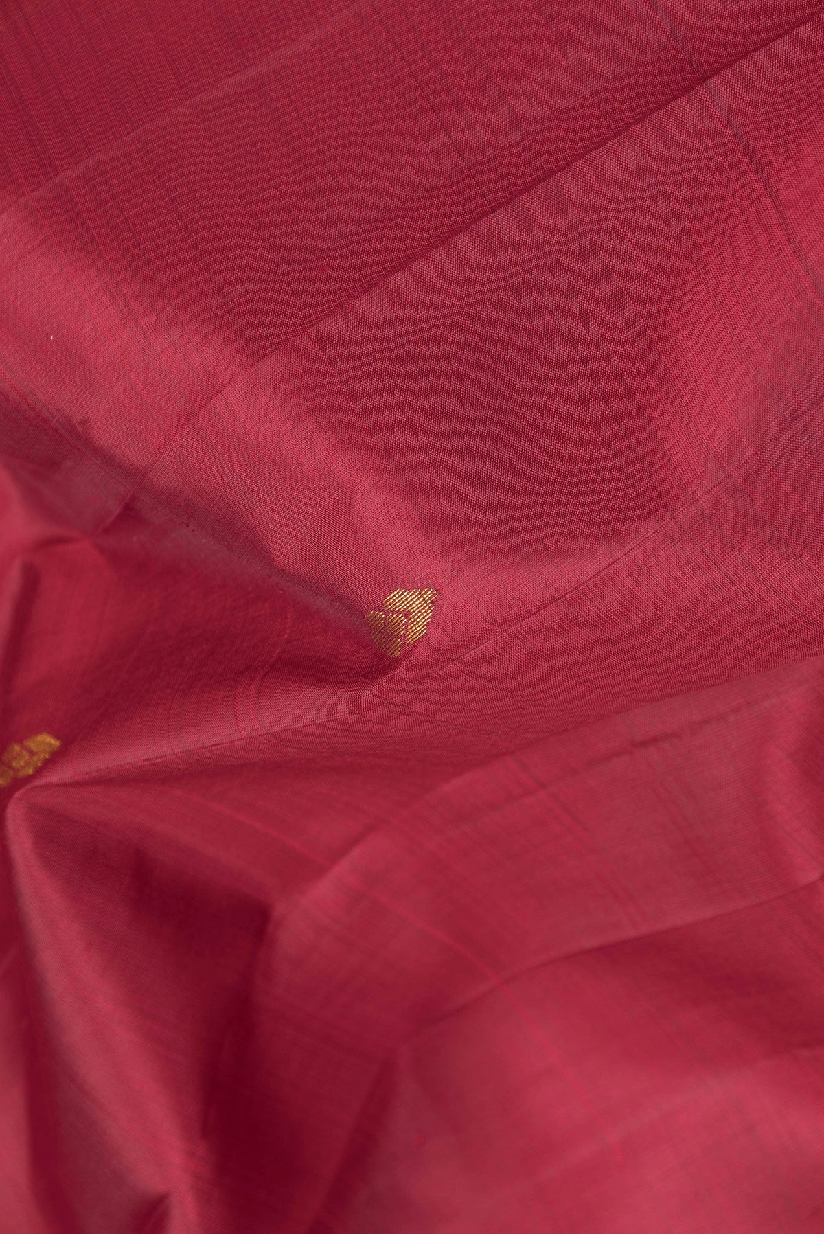 Close up of Maroon Kanjivaram Silk Saree with Zari Butta on the body and One Side Border.  displaying folds
