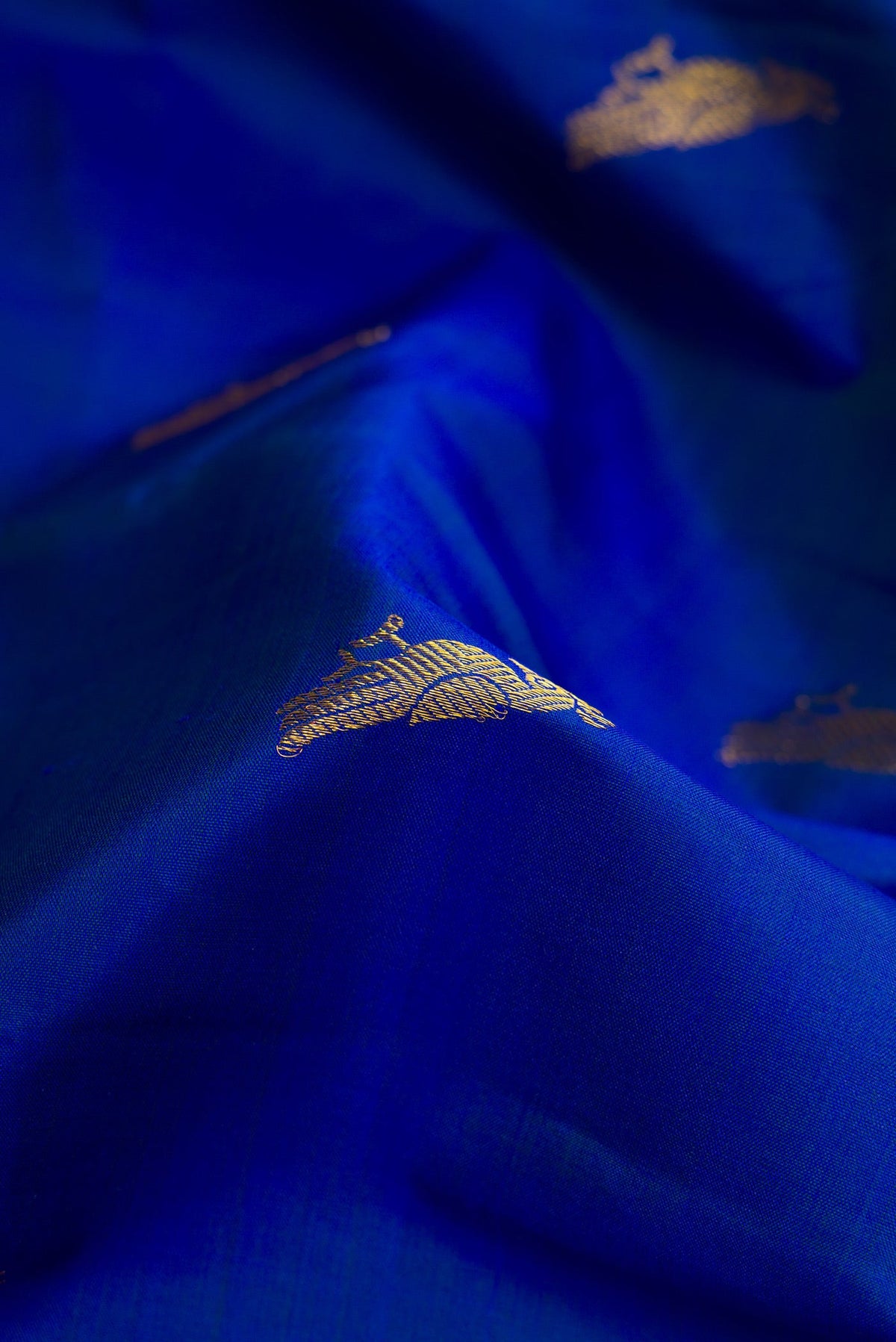 Close up of Royal Blue Dual Tone Kanchipuram Silk Saree with Zari Butta on the body and Zari Border.  displaying folds