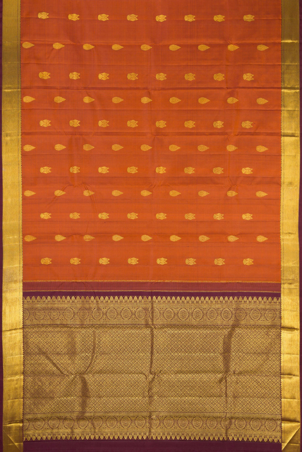 Flat view of Brick Orange Dual Tone Kanjivaram Silk Saree with Zari Butta on the body and Zari Border. 