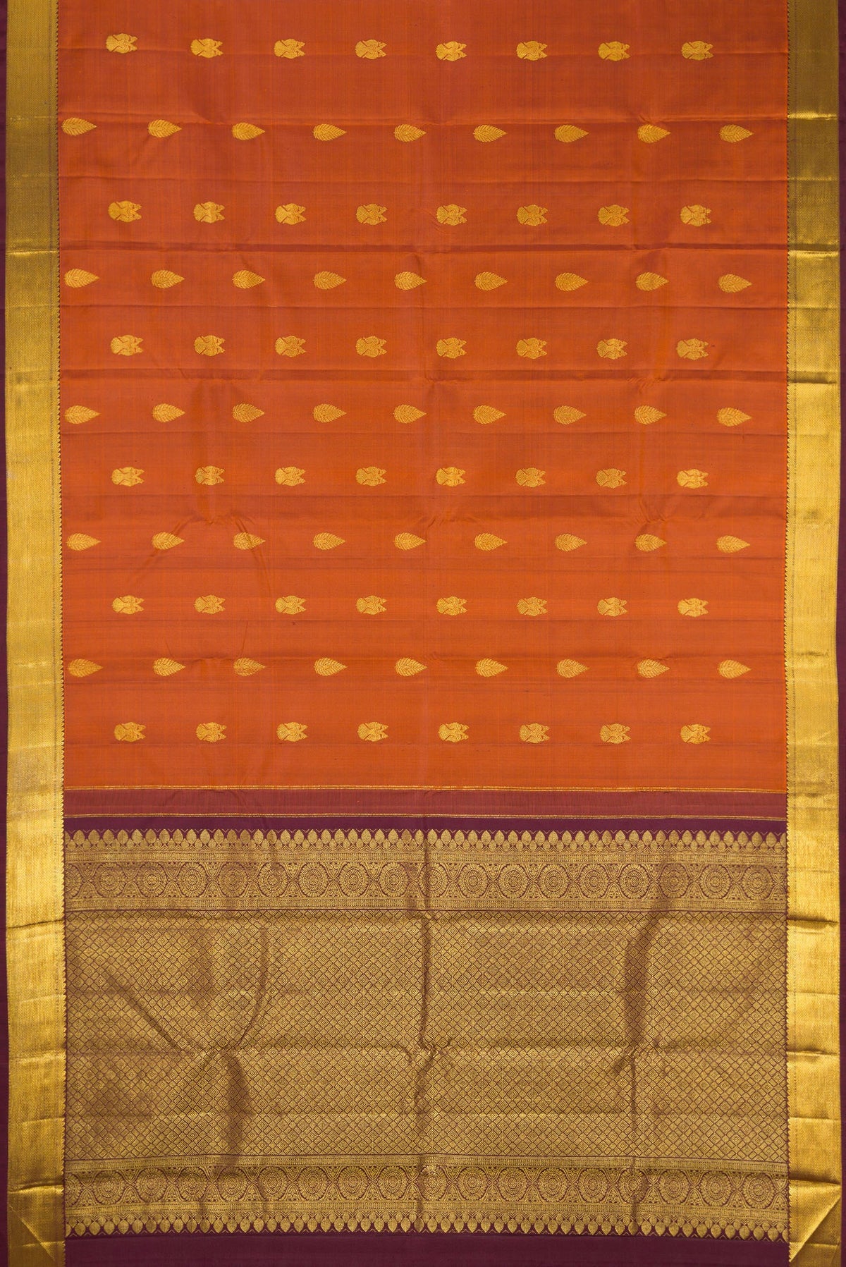 Flat view of Brick Orange Dual Tone Kanjivaram Silk Saree with Zari Butta on the body and Zari Border. 