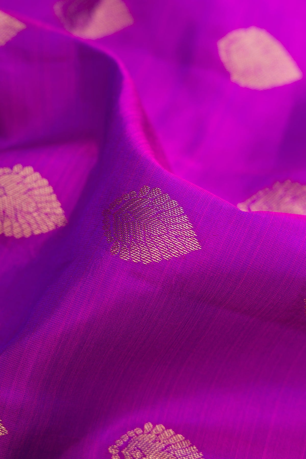 Close up of Purple Kanchipuram Silk Saree with Zari Butta on the body and Zari Border.  displaying folds