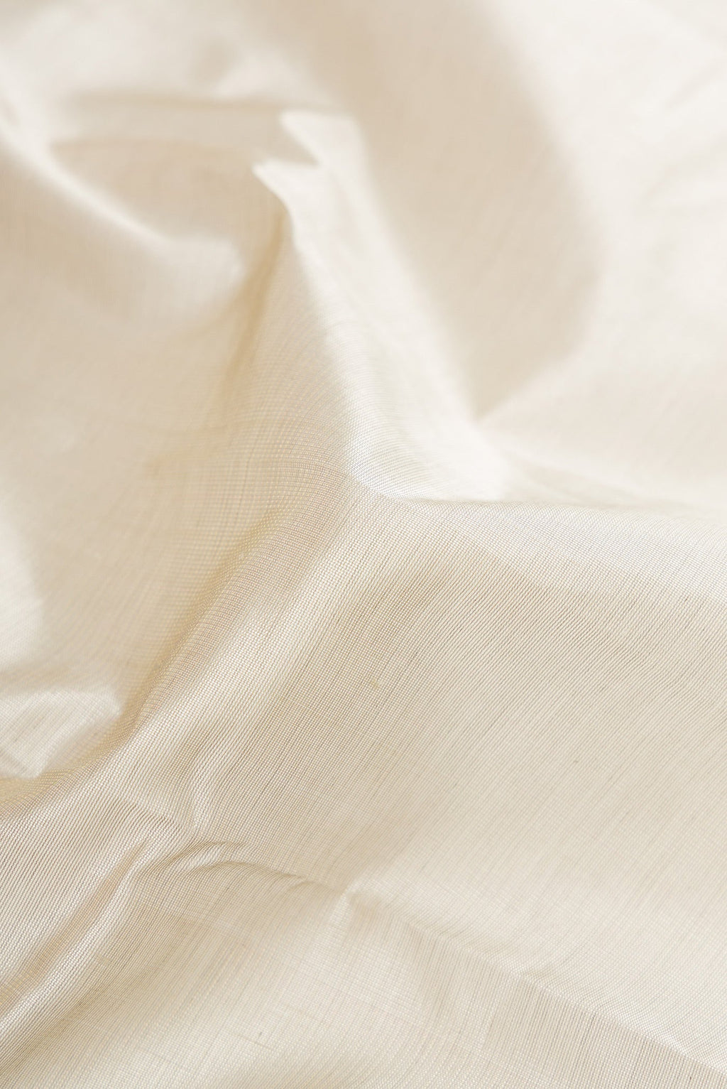 Close up of Grey Silk Cotton Saree with Plain Body and Zari Border.  displaying folds