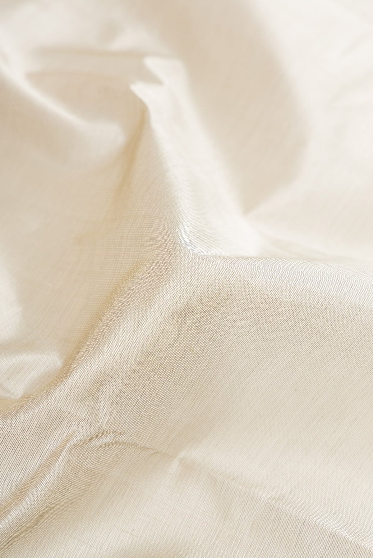 Close up of Grey Silk Cotton Saree with Plain Body and Zari Border.  displaying folds