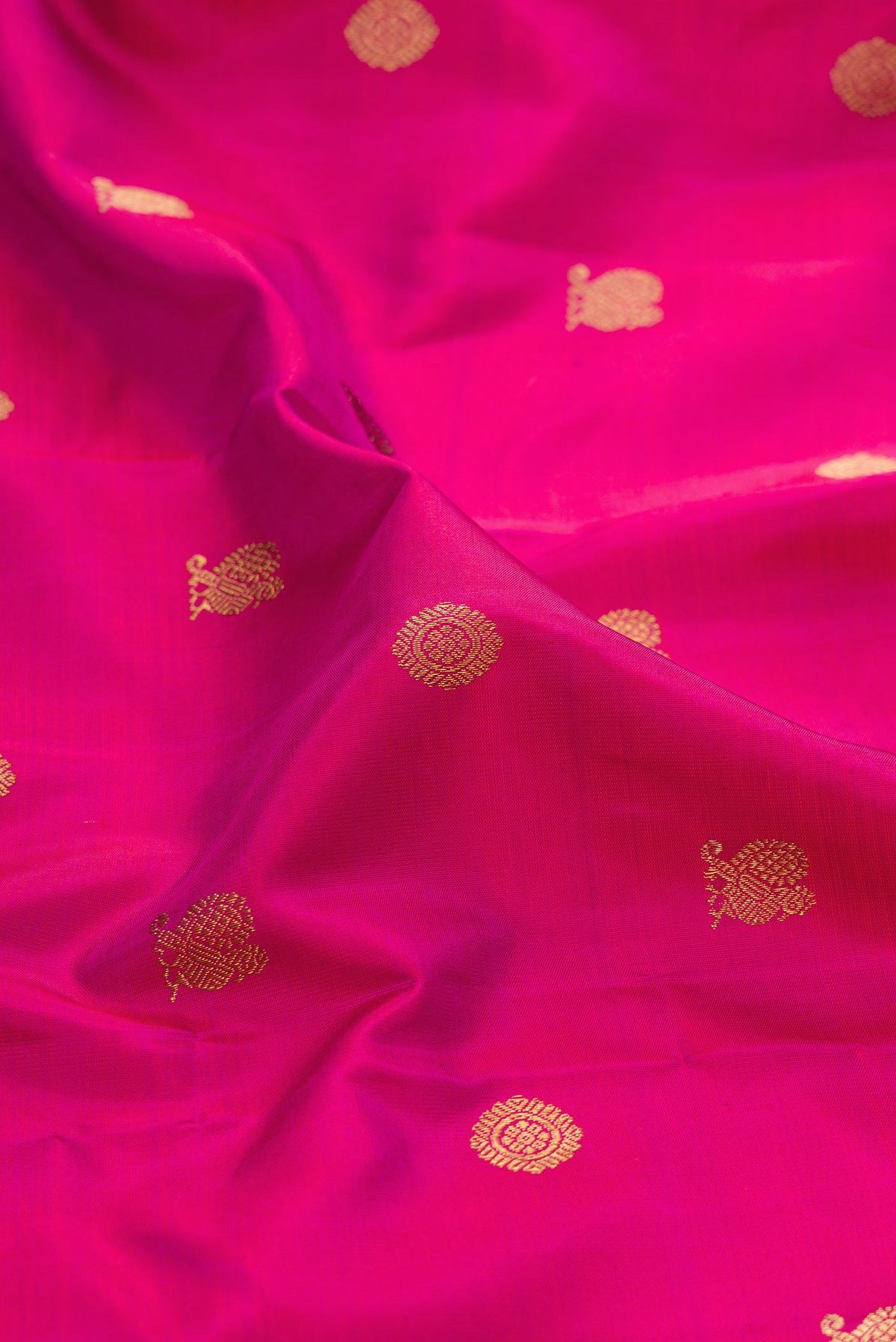 Close up of Pure Silk Pure Zari Magenta Kanjivaram Saree with Zari Butta on the body and Zari Border.  displaying folds
