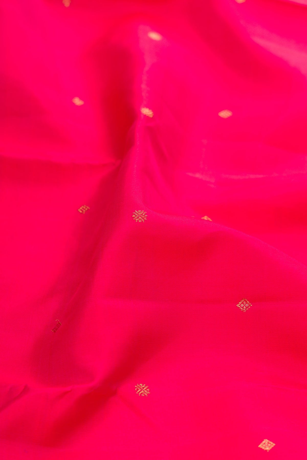 Close up of Pure Silk Pure Zari Pink Kanjivaram Saree with Zari Butta on the body and Zari Border.  displaying folds
