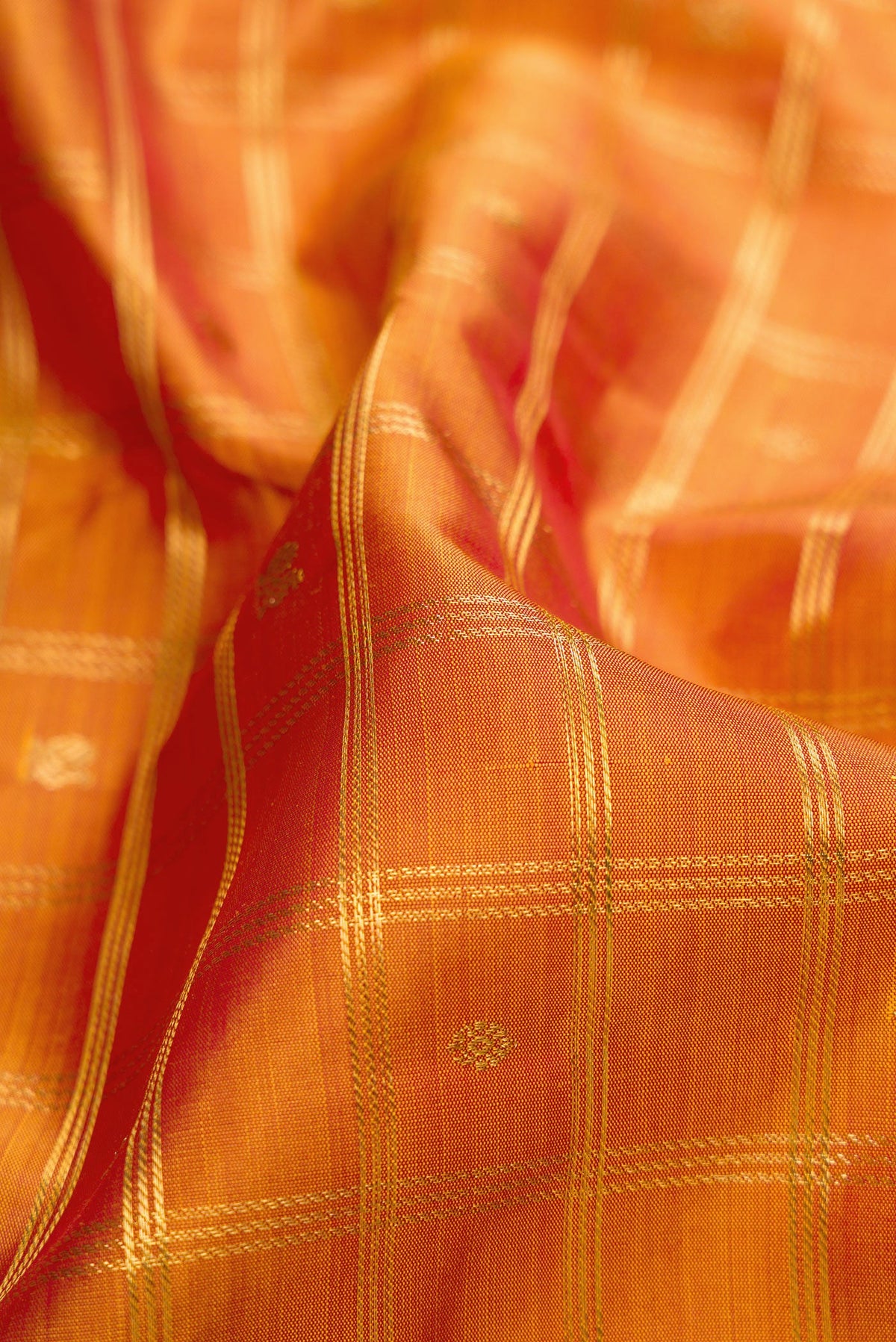 Close up of Pure Silk Pure Zari Mustard Dual Tone Kanjivaram Saree with Checked design on the body and Zari Border.  displaying folds