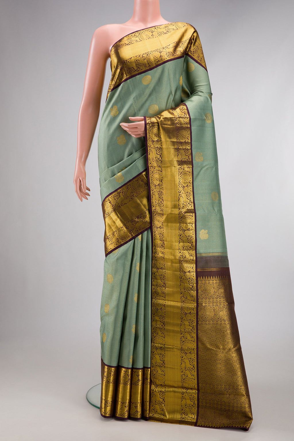 Green Dual Tone Kanchipuram Silk Saree with Checked design on the body and Fancy Border.  displayed on a mannequin