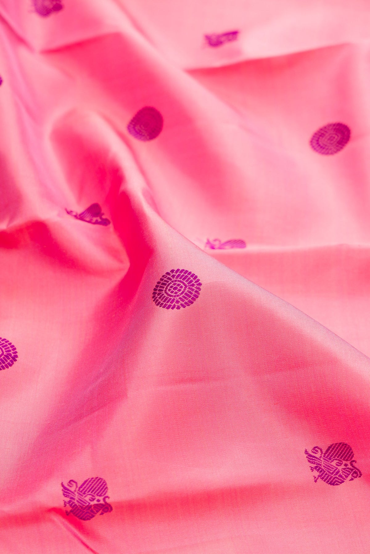 Close up of Pure Silk Pure Zari Pink Kanchipuram Saree with Thread Butta on the body and Zari Border.  displaying folds