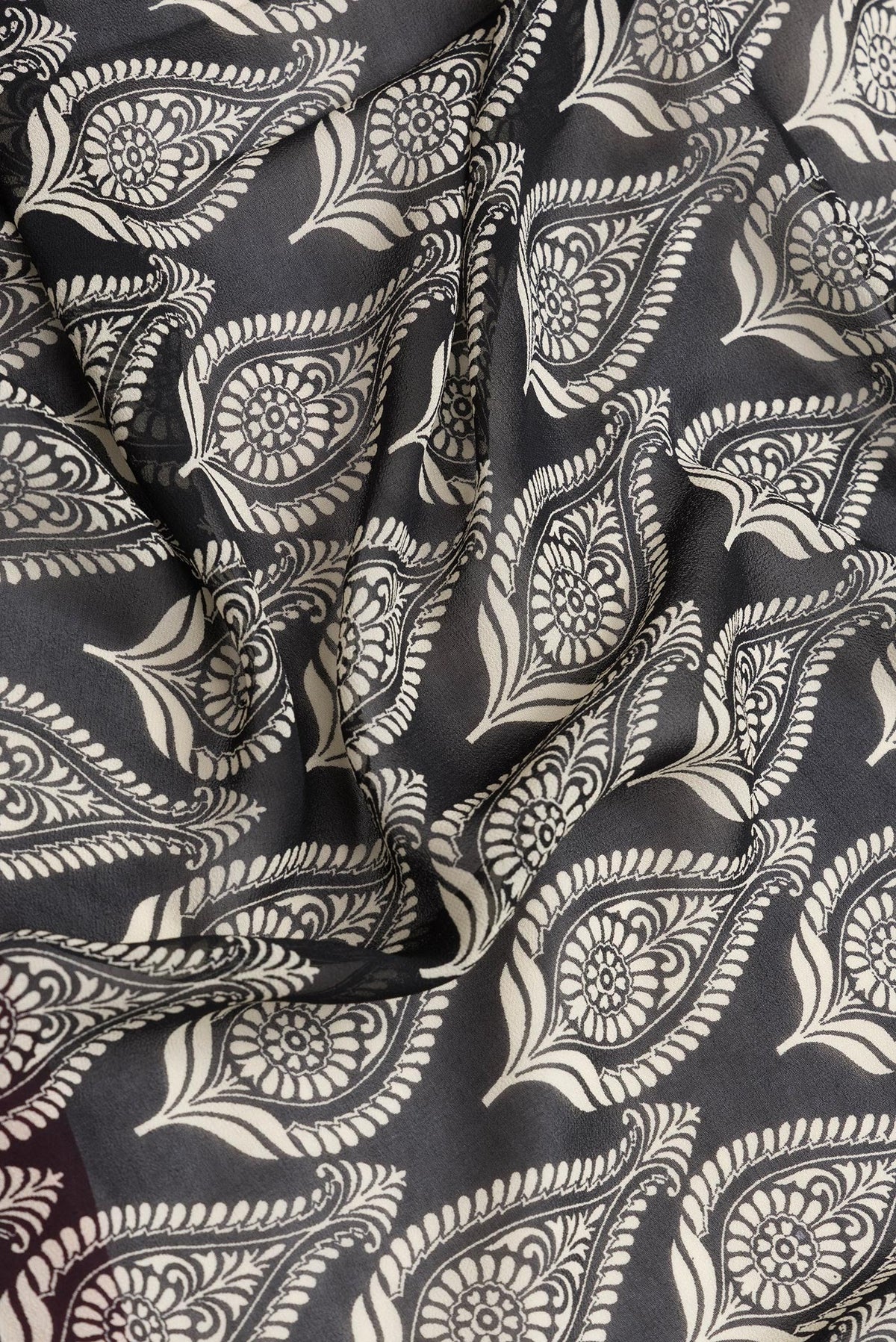 Close up of Black Dual Tone Mysore Georgette Saree with Printed design on the body and Zari Border.  displaying folds