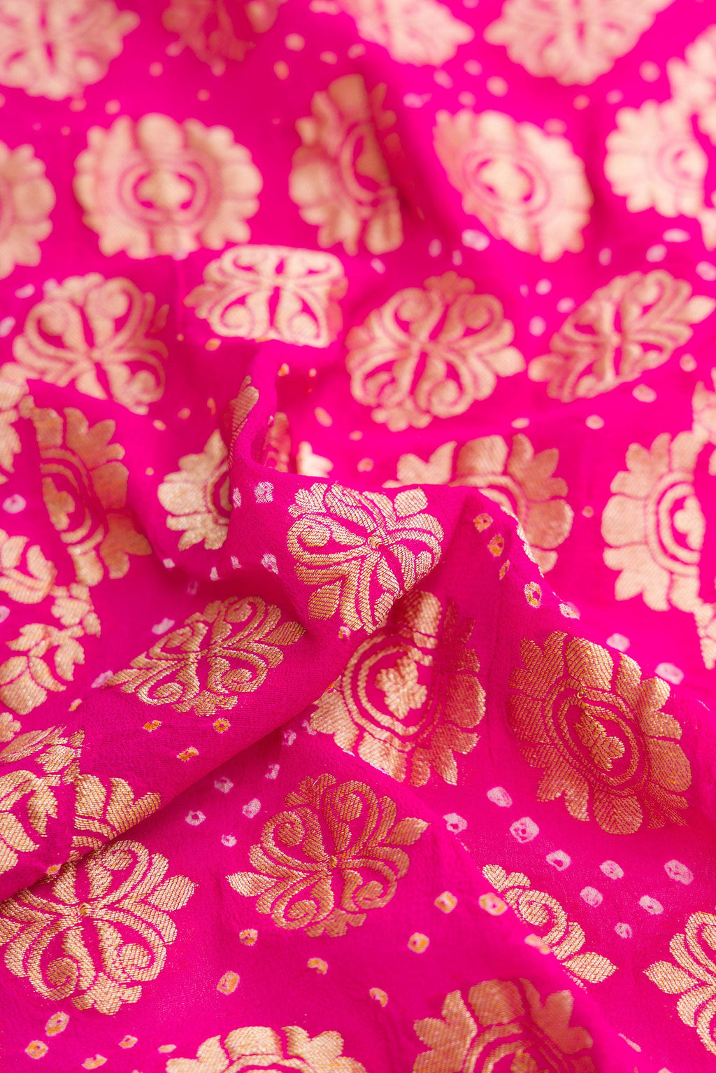 Close up of Pink and Red Color Bandhani Silk Saree with Bandhani Print on the body and Zari Border.  displaying folds