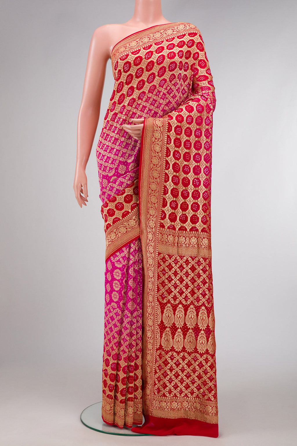 Pink and Red Color Bandhani Silk Saree with Bandhani Print on the body and Zari Border.  displayed on a mannequin