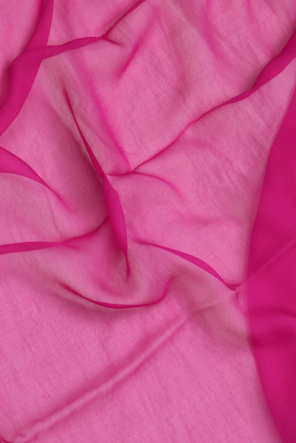 Close up of Pink Dual Tone Georgette Saree with Plain Body and Zari Border.  displaying folds