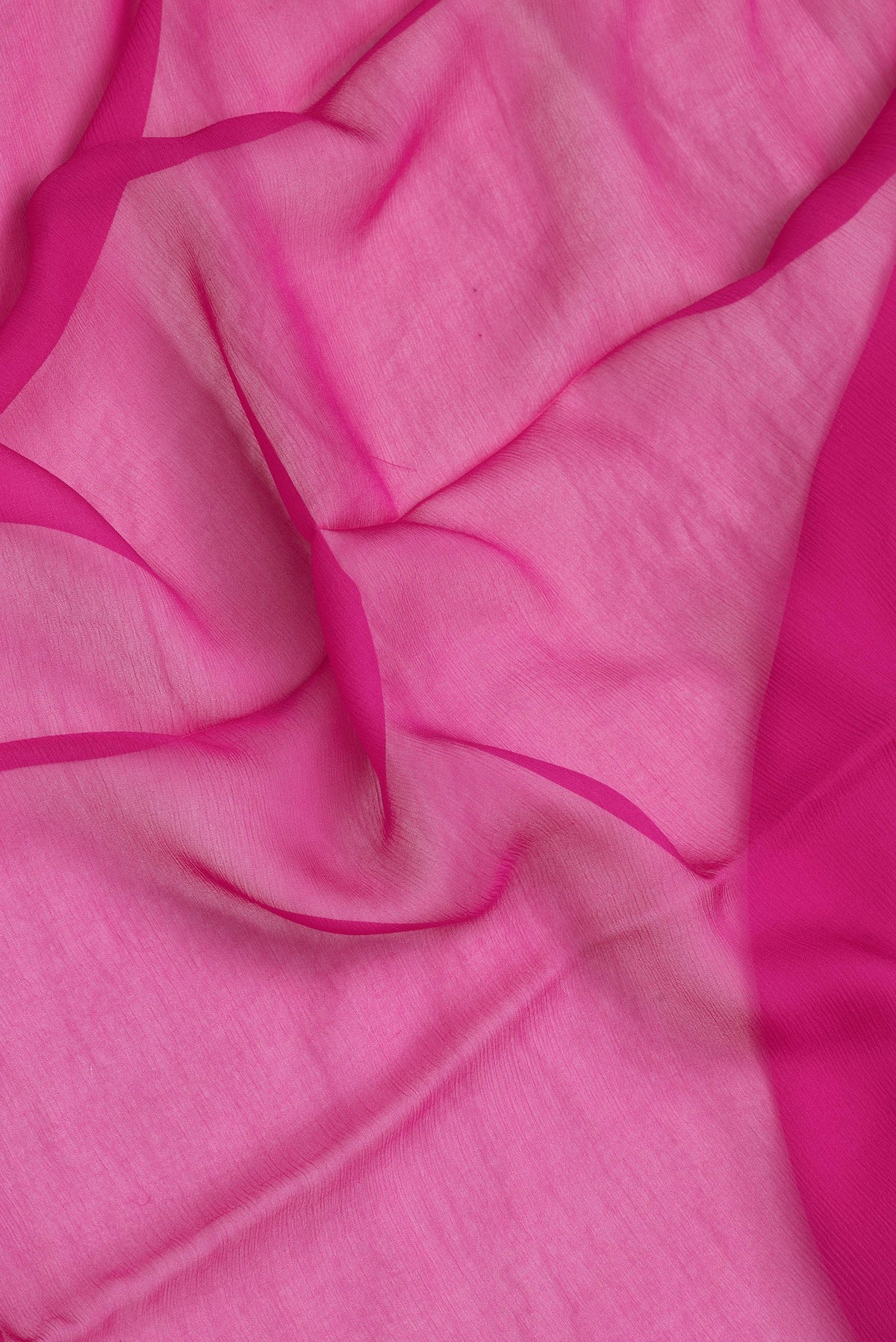 Close up of Pink Dual Tone Georgette Saree with Plain Body and Zari Border.  displaying folds