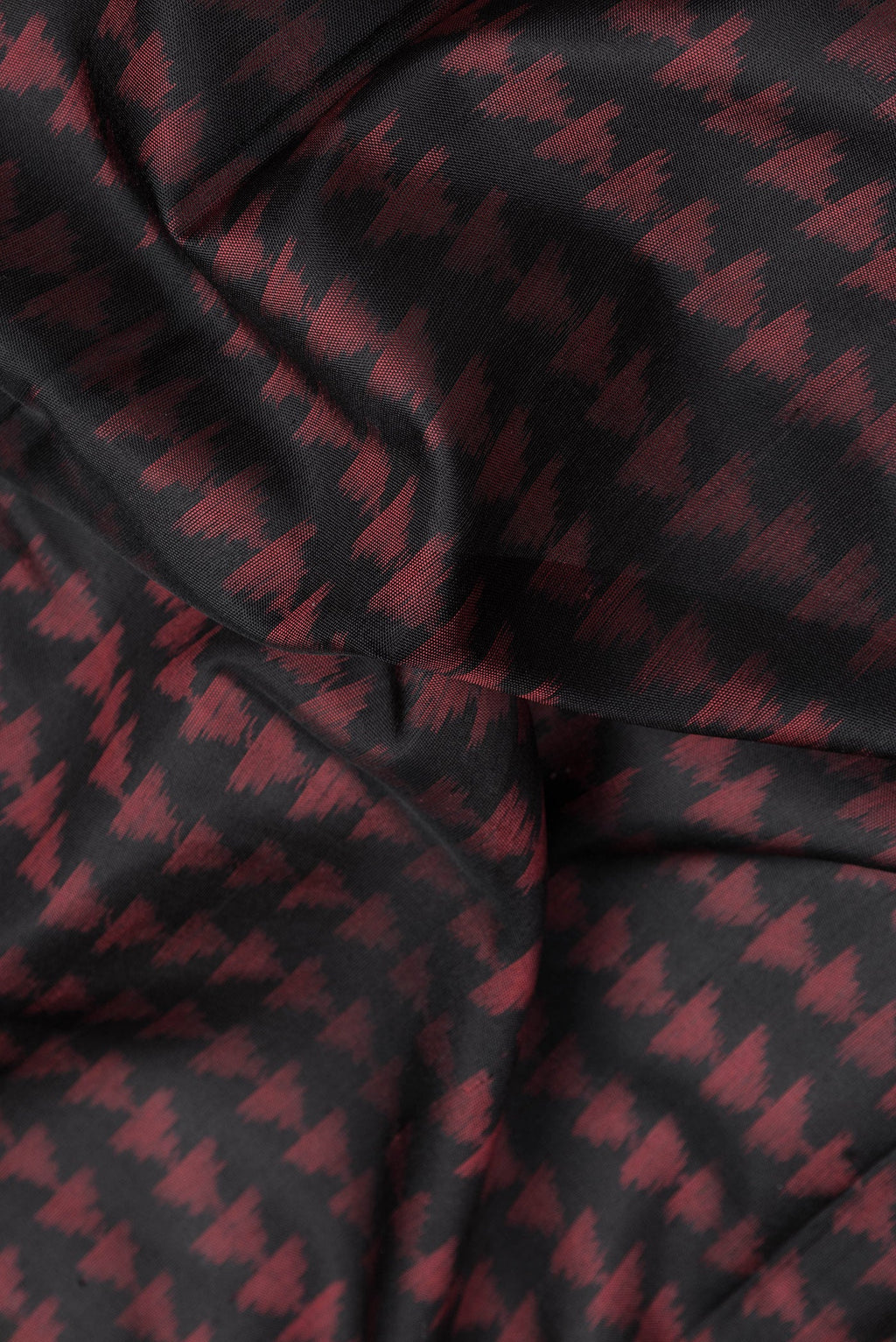 Close up of Black Dual Tone Double Ikat Saree with Ikat Print on the body and Fancy Border.  displaying folds