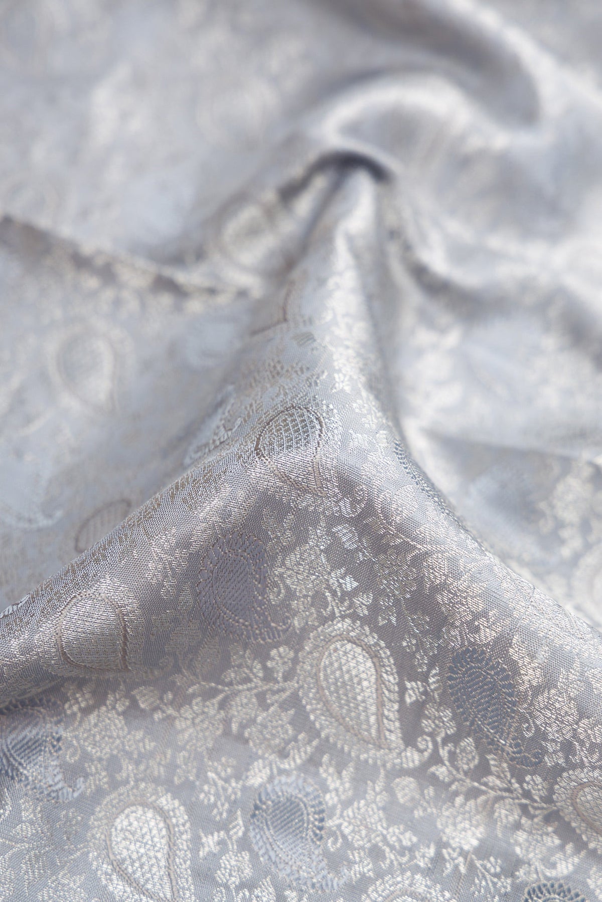 Close up of Grey Dual Tone Kanchipuram Silk Saree with Jacquard With Zari Butta on the body and Zari Border.  displaying folds