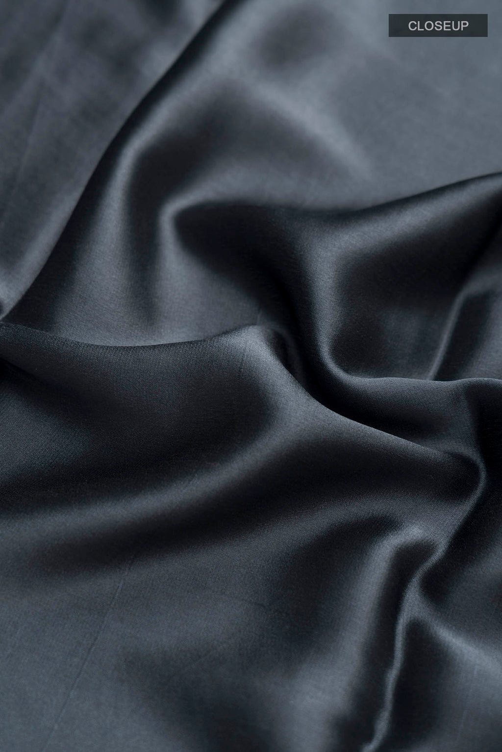Close up of Grey Satin Silk Saree with Plain Body and Zari Border displaying folds