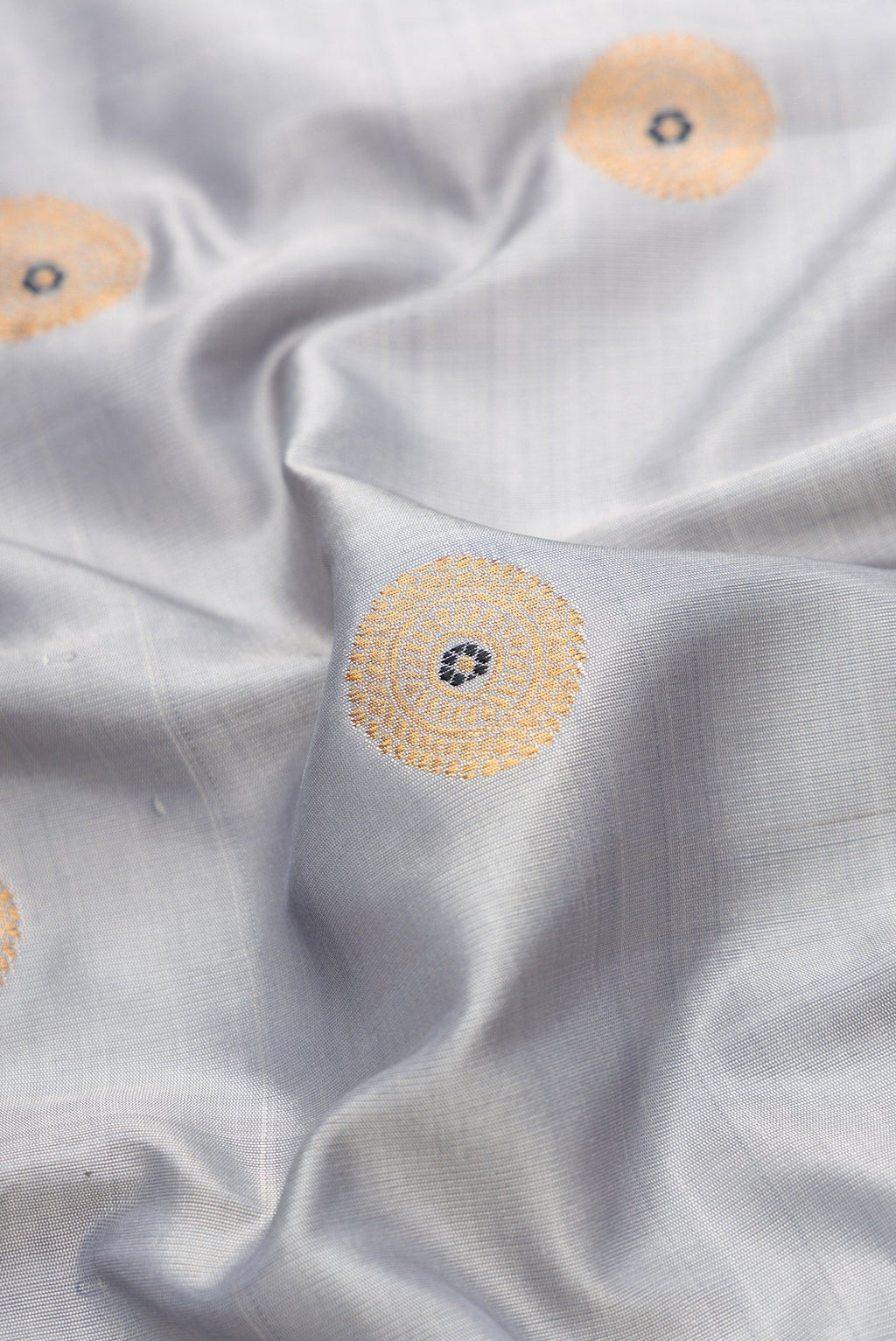 Close up of Grey Dual Tone Gadwal Silk Saree with Zari And Thread Butta on the body and Ganga Jamuna Border.  displaying folds