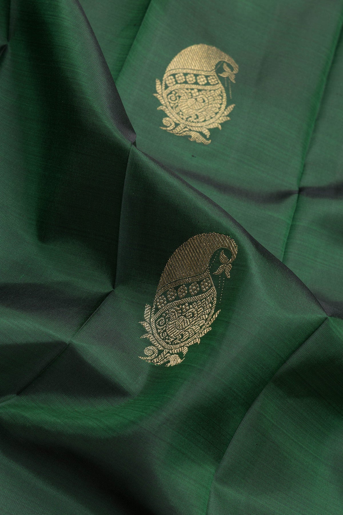 Close up of Bottle Green Dual Tone Kanchipuram Silk Saree with Zari Butta on the body and Zari Border.  displaying folds