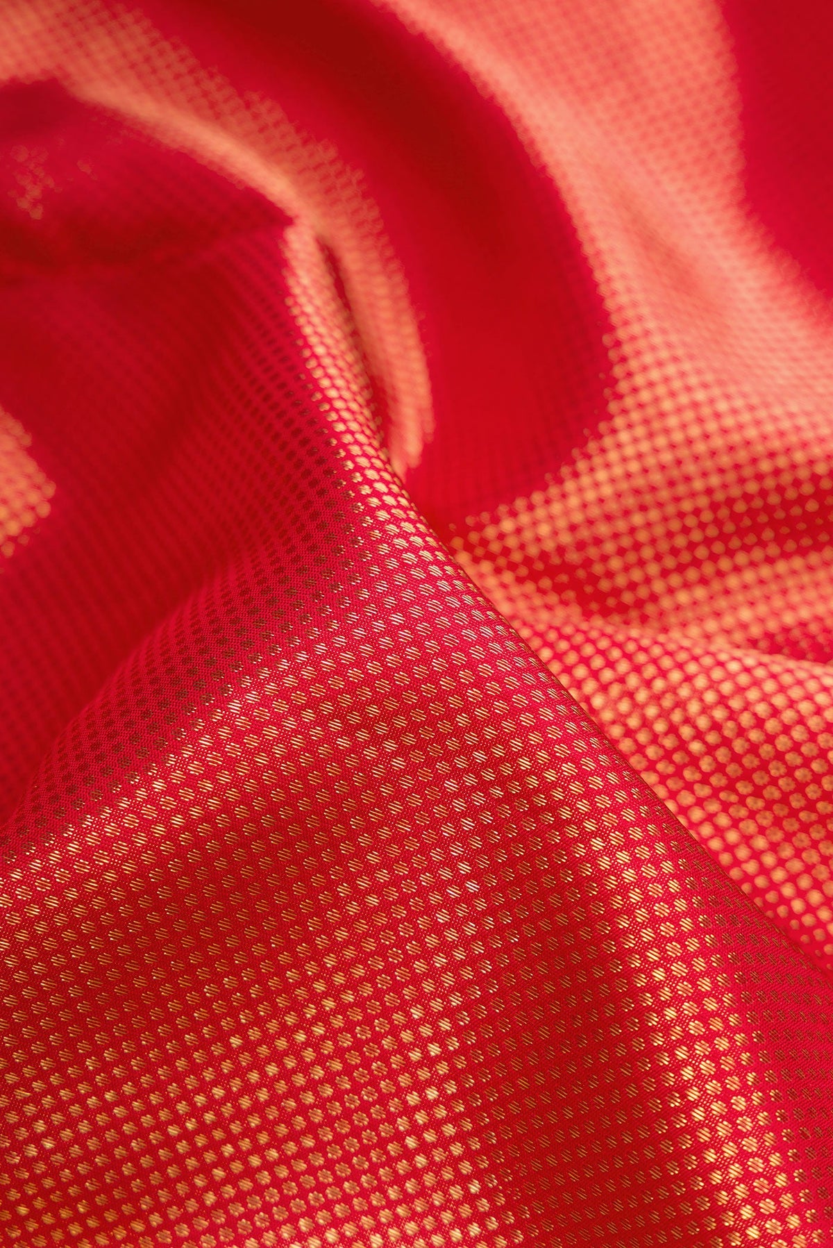 Close up of Pure Silk Pure Zari Red Dual Tone Kanjivaram Saree with Zari Brocade on the body and Zari Border.  displaying folds