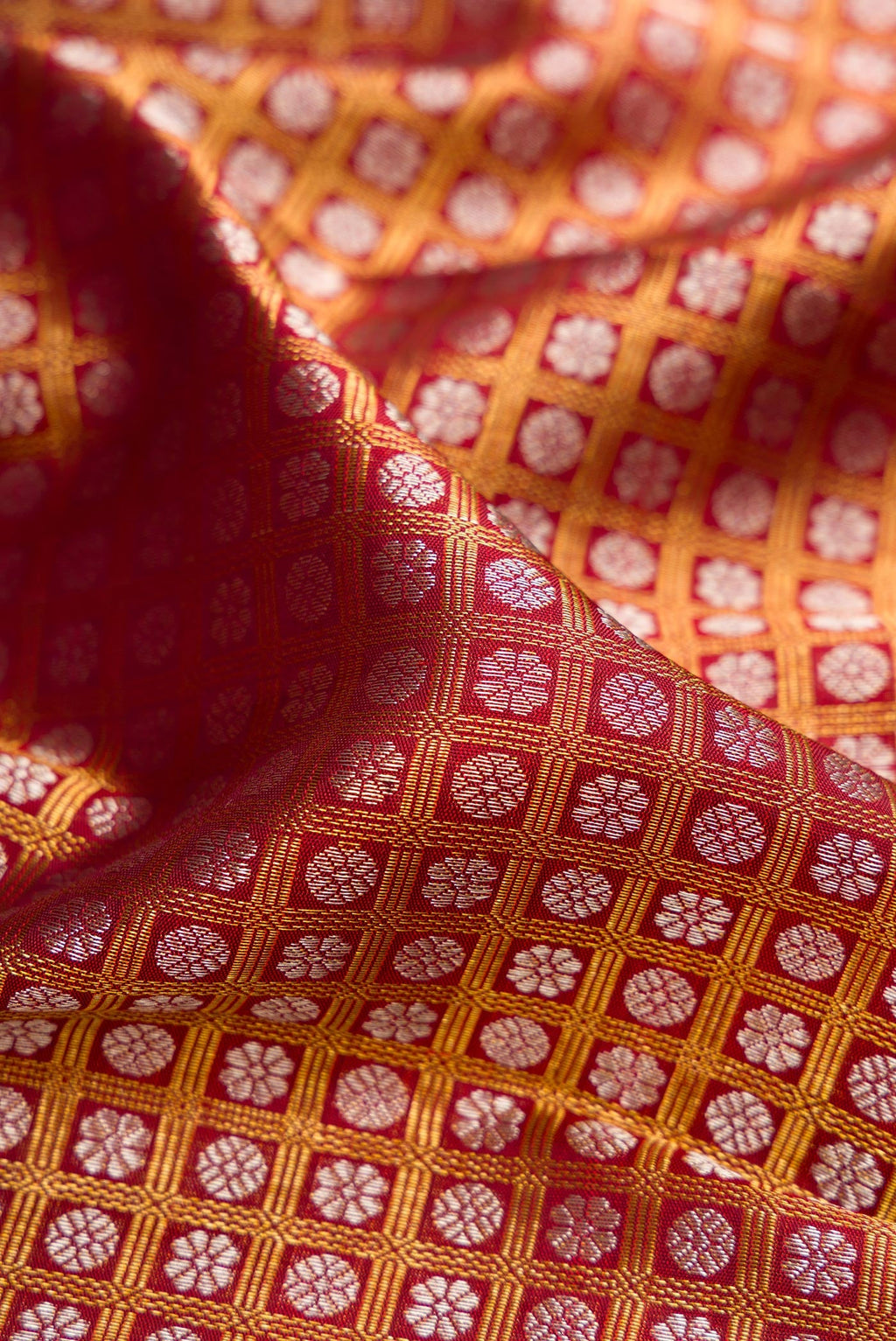 Close up of Maroon Kanchipuram Silk Saree with Zari Brocade on the body and Zari Border.  displaying folds