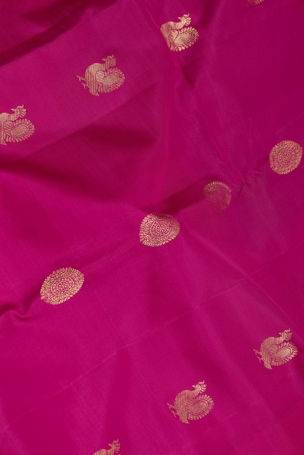 Close up of Magenta Dual Tone Kanchipuram Saree with Zari Butta on the body and Zari Border displaying folds