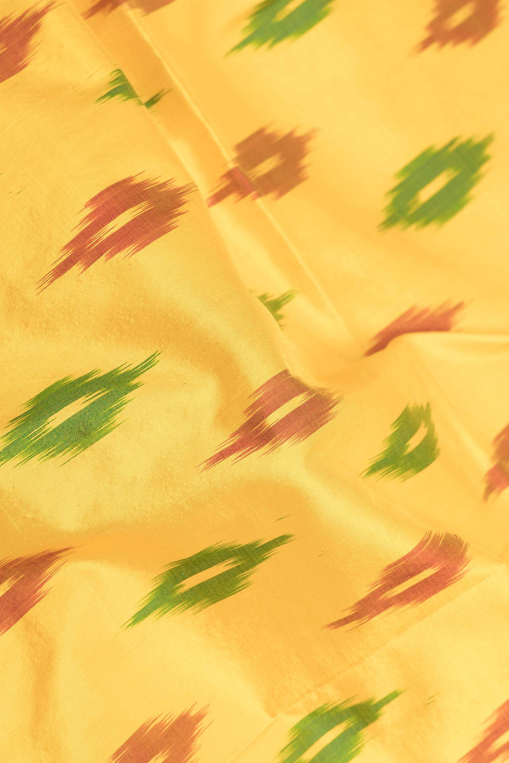 Close up of Yellow Dual Tone Double Ikat Saree with Ikat Print on the body and Zari Border displaying folds