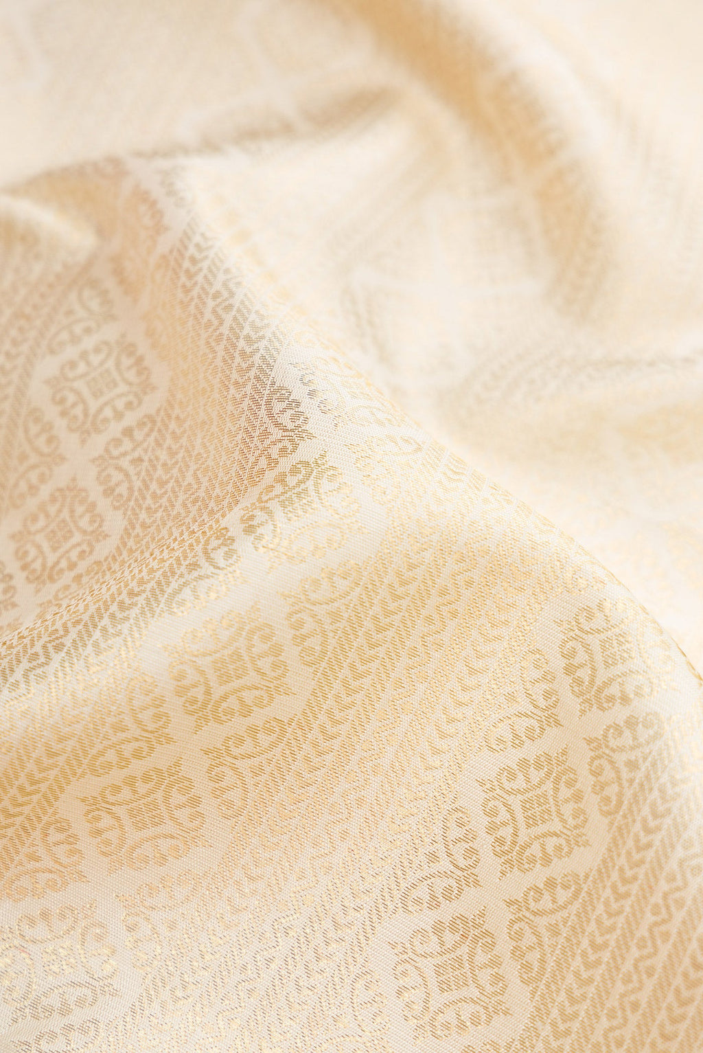 Close up of Pure Silk Pure Zari Off White Dual Tone Kanjivaram Saree with Zari Brocade on the body and Zari Border.  displaying folds