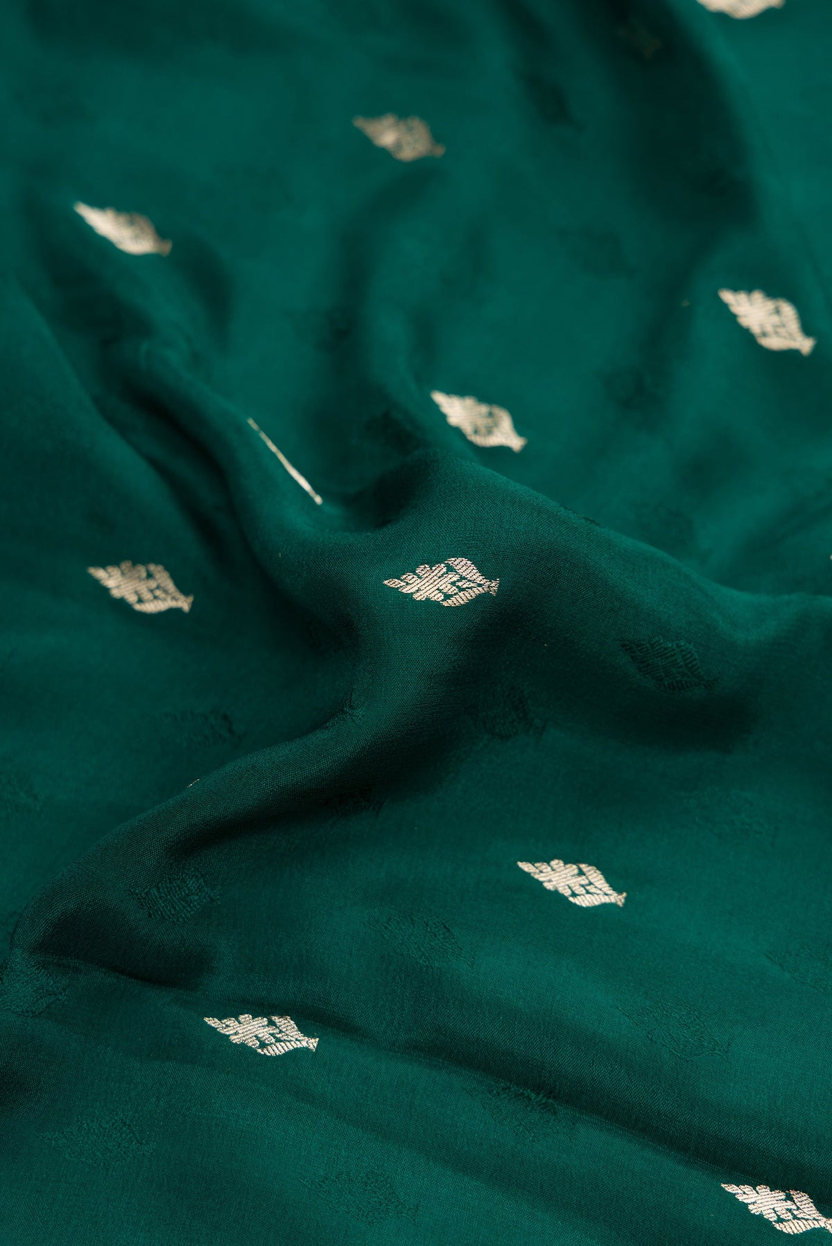 Close up of Bottle Green Dual Tone Mysore Georgette Saree with Zari Butta on the body and Zari Border.  displaying folds