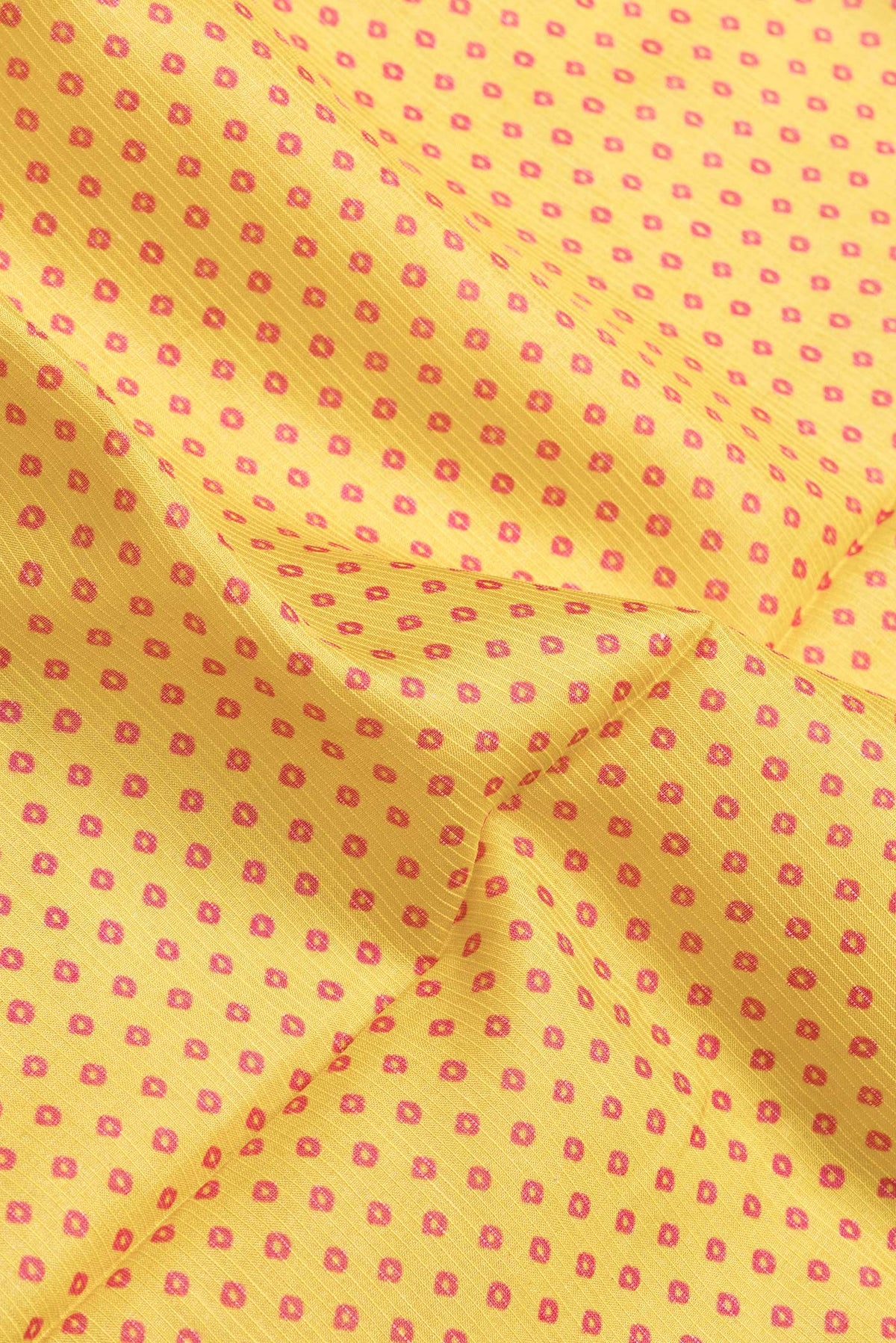 Close up of Yellow Dual Tone Tussar Silk Saree with Bandhani Print on the body and Zari Border.  displaying folds
