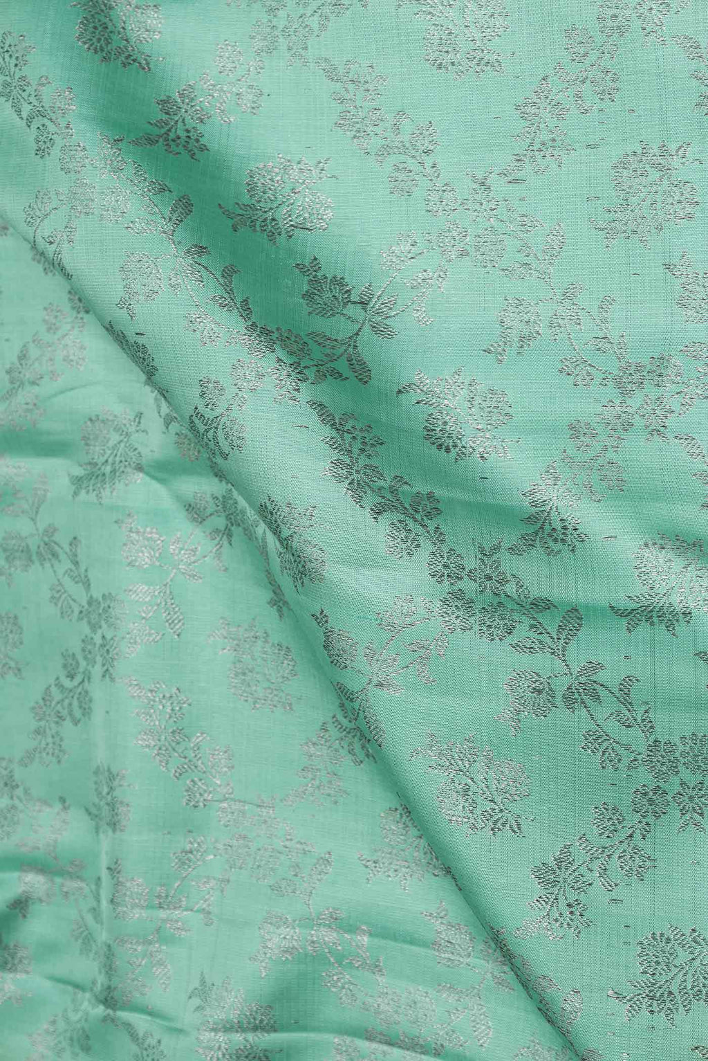 Close up of Sea Green Dual Tone Kanchipuram Silk Saree with Zari Brocade on the body and Zari Border displaying folds