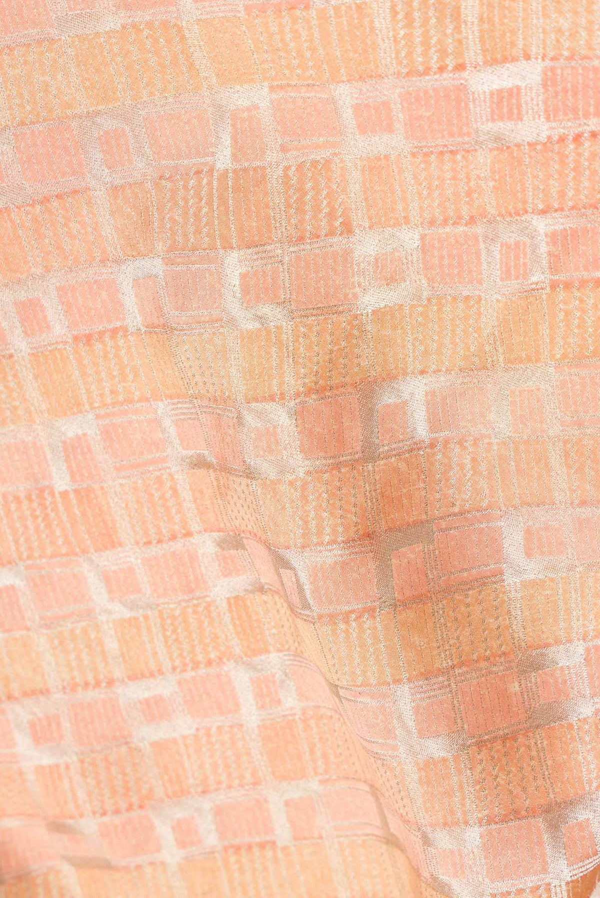 Close up of Golden Peach Dual Tone Banarasi Silk Saree with Zari Brocade on the body and Zari Border.  displaying folds