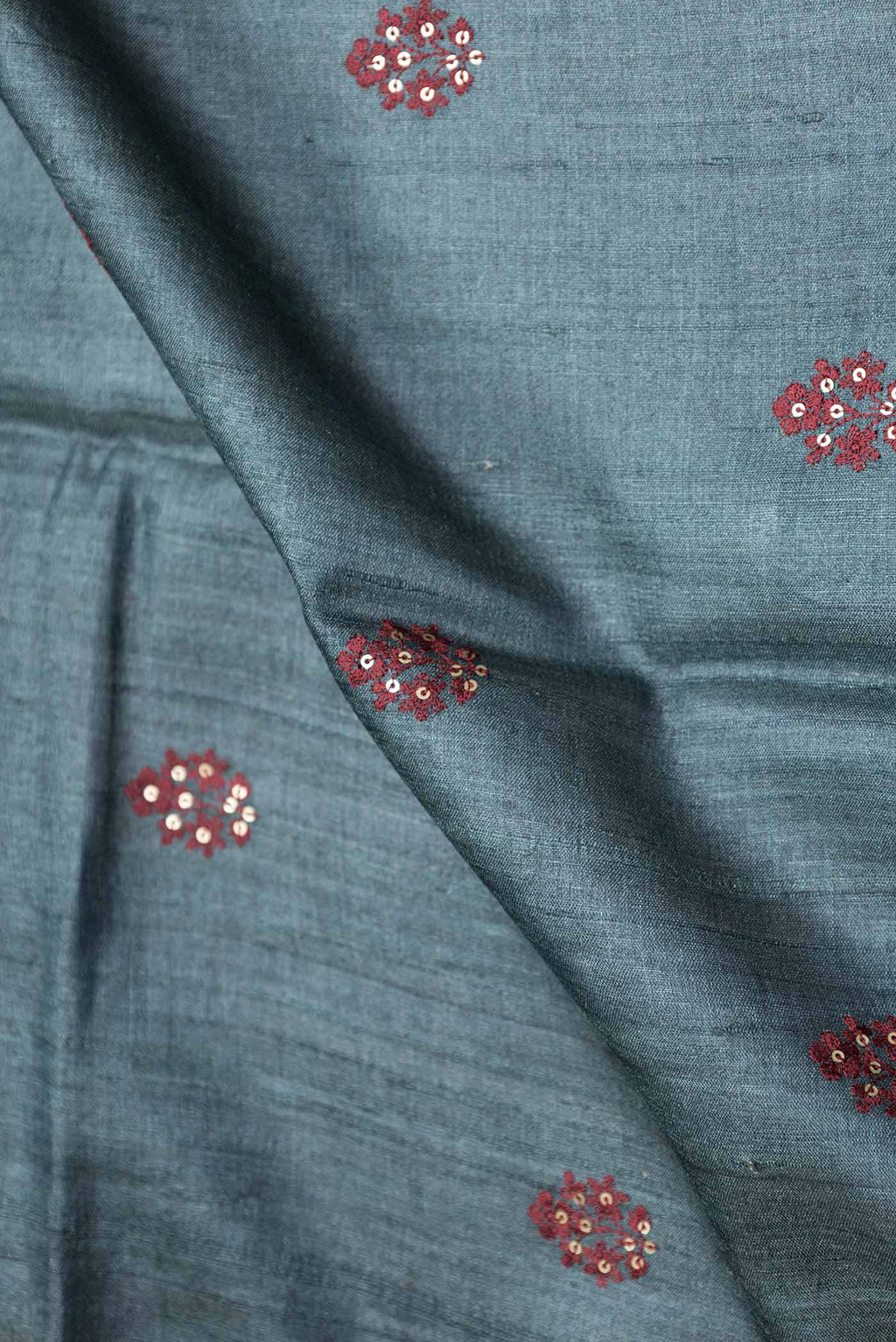 Close up of Grey Dual Tone Tussar Silk Saree with Embroidery on the body and Embroidery Border displaying folds