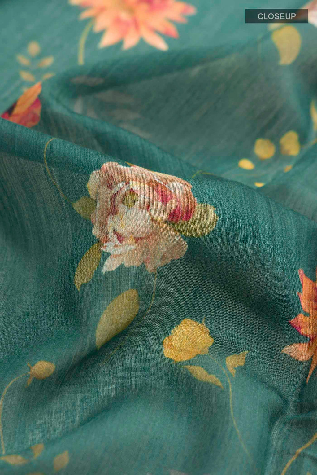 Close up of Green Tussar Silk Saree with Printed design on the body and Zari Border displaying folds