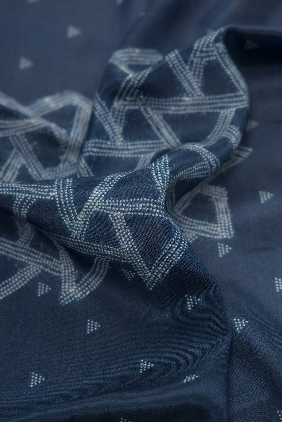 Close up of Navy Blue Dual Tone Mysore Crepe Saree with Printed design on the body and Zari Border.  displaying folds