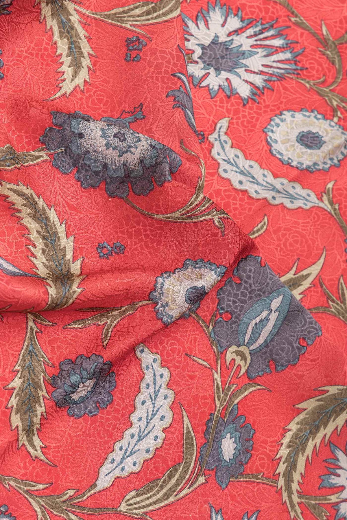 Close up of Orange Dual Tone Mysore Crepe Saree with Printed design on the body and Zari Border.  displaying folds