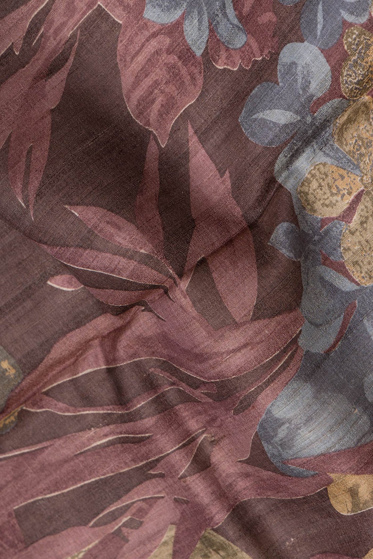 Close up of Maroon Dual Tone Tussar Silk Saree with Printed design on the body and Zari Border.  displaying folds