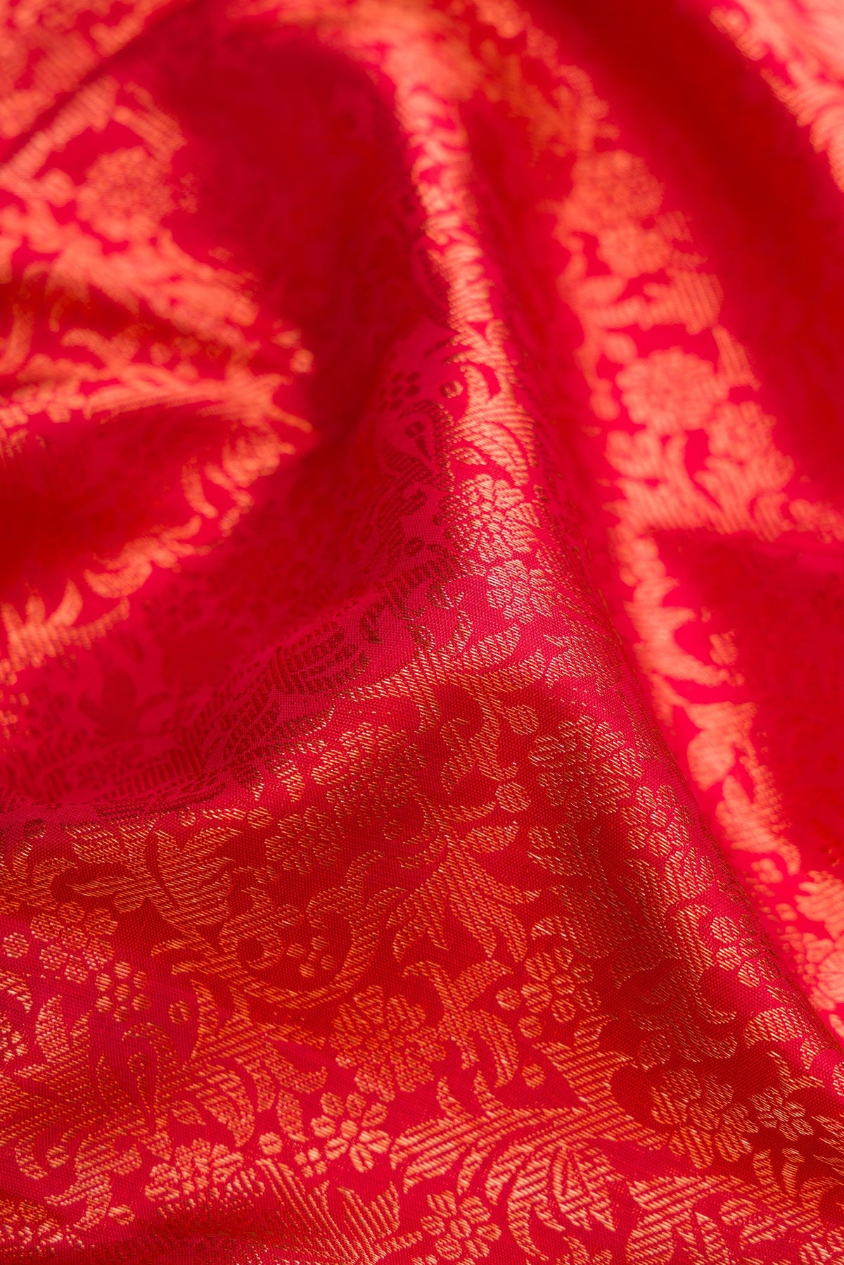 Close up of Red Dual Tone Kanjivaram Silk Saree with Zari Brocade on the body and Zari Border.  displaying folds