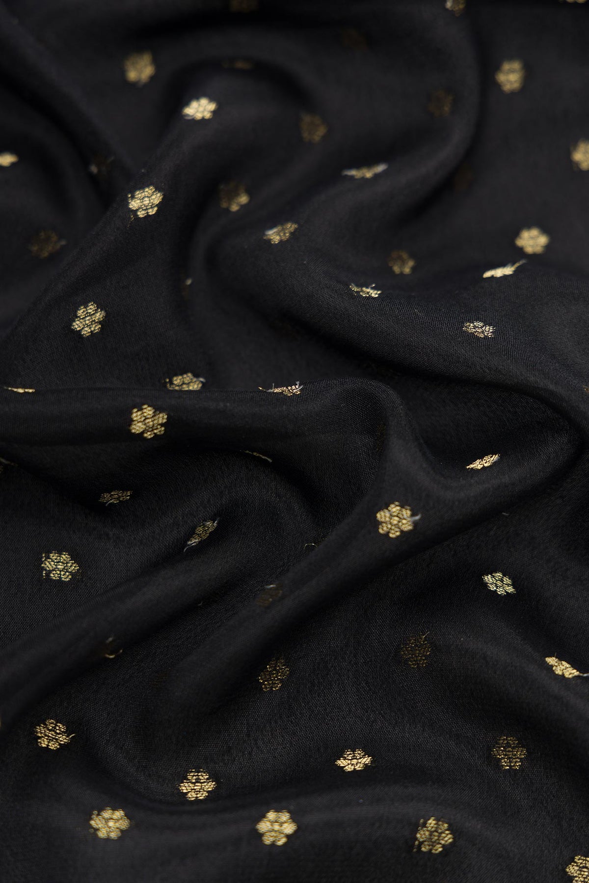 Close up of Black Dual Tone Mysore Crepe Saree with Zari Butta on the body and Fancy Border.  displaying folds